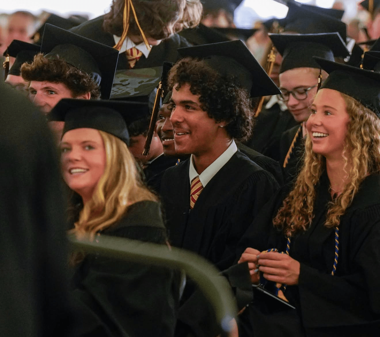 Hudson smiling among classmates at his high school graduation